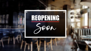 Reopening soon sign in front of an empty restaurant shown blurred in the background illustrates business downtime in the wake of a disaster and the urgency to recover as soon as possible.